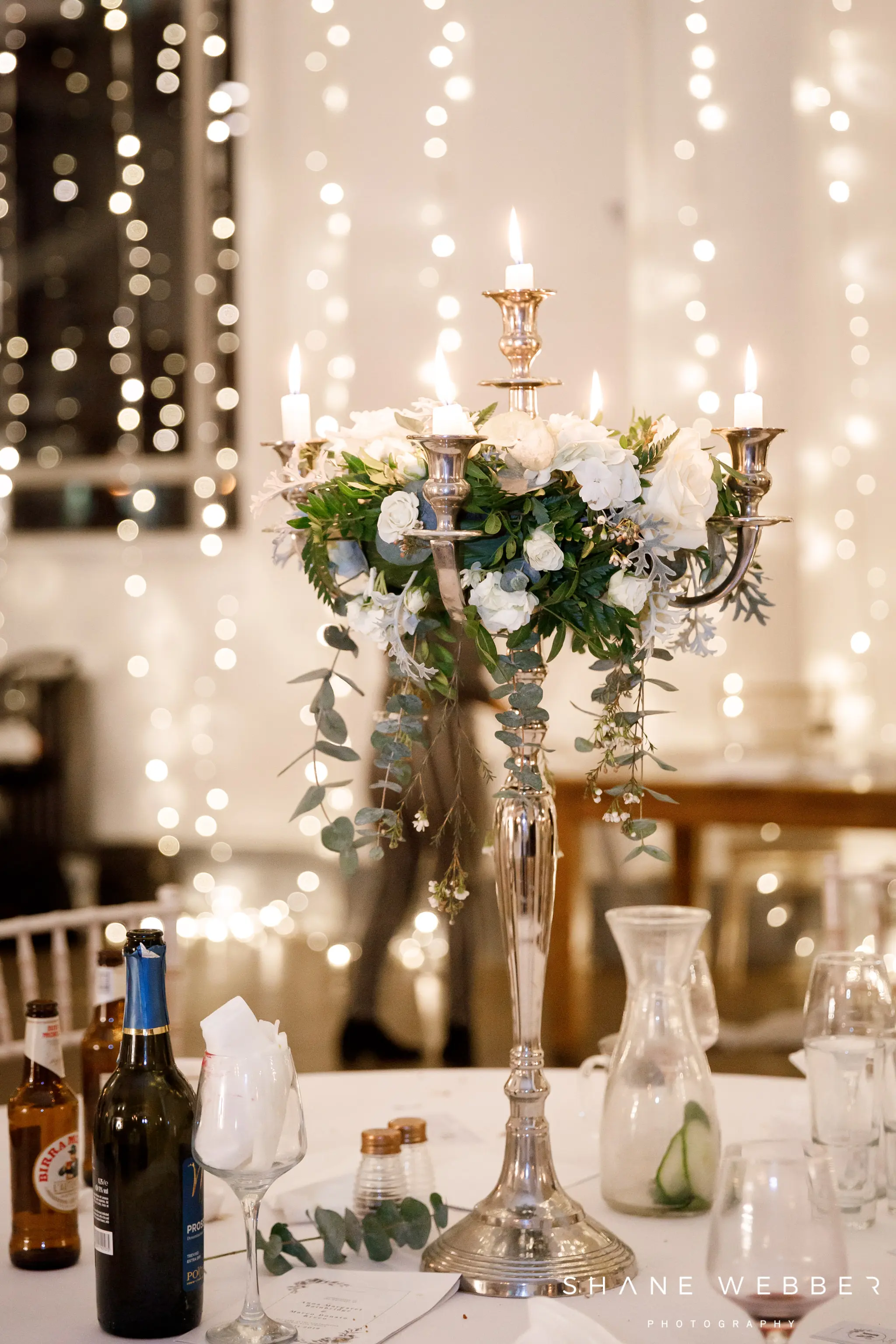 White flowers for December wedding on a tall candelabra table arrangement